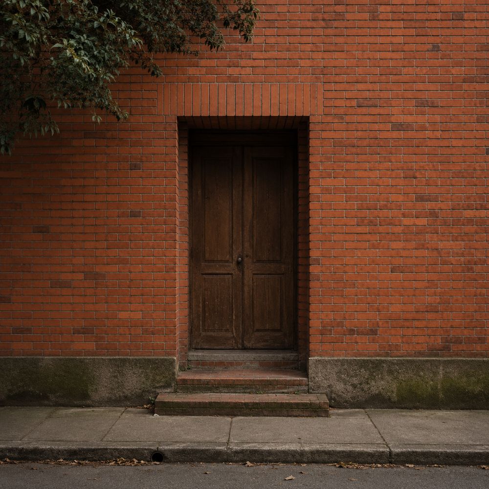 A closed wooden door set into a red brick facade.